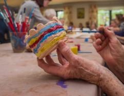 Hands shaping colorful pottery during an occupational therapy activity